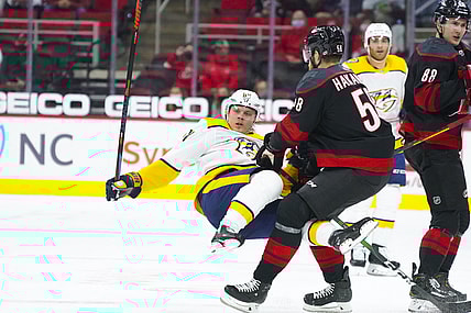 Apr 15, 2021; Raleigh, North Carolina, USA;  Carolina Hurricanes defenseman Jani Hakanpaa (58) checks Nashville Predators center Mikael Granlund (64) during the first period at PNC Arena. Mandatory Credit: James Guillory-USA TODAY Sports