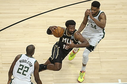 Apr 15, 2021; Atlanta, Georgia, USA; Atlanta Hawks forward Solomon Hill (18) drives on Milwaukee Bucks forward Giannis Antetokounmpo (34) and forward Khris Middleton (22) in the second quarter at State Farm Arena. Mandatory Credit: Brett Davis-USA TODAY Sports