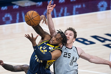 Apr 19, 2021; Indianapolis, Indiana, USA; Indiana Pacers forward Oshae Brissett (12) rebounds the ball over San Antonio Spurs center Jakob Poeltl (25)  in the second quarter at Bankers Life Fieldhouse. Mandatory Credit: Trevor Ruszkowski-USA TODAY Sports