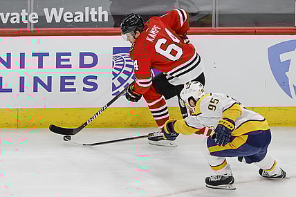 Apr 23, 2021; Chicago, Illinois, USA; Chicago Blackhawks center David Kampf (64) keeps the puck away from Nashville Predators center Matt Duchene (95) during the first period at United Center. Mandatory Credit: Kamil Krzaczynski-USA TODAY Sports