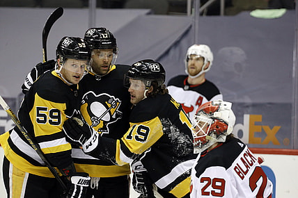 Apr 24, 2021; Pittsburgh, Pennsylvania, USA;  Pittsburgh Penguins center Jared McCann (19) celebrates his power play goal against New Jersey Devils goaltender Mackenzie Blackwood (29) with Pens left wing Jake Guentzel (59) and right wing Bryan Rust (17) during the first period at PPG Paints Arena. Mandatory Credit: Charles LeClaire-USA TODAY Sports
