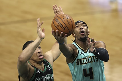 Apr 25, 2021; Charlotte, North Carolina, USA; Charlotte Hornets guard Devonte' Graham (4) drives to the basket against Boston Celtics forward Grant Williams (12) during the first quarter at Spectrum Center. Mandatory Credit: Nell Redmond-USA TODAY Sports