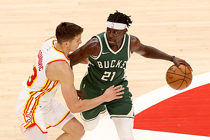 Apr 25, 2021; Atlanta, Georgia, USA; Milwaukee Bucks guard Jrue Holiday (21) controls the ball against Atlanta Hawks guard Bogdan Bogdanovic (13) during the second quarter at State Farm Arena. Mandatory Credit: Jason Getz-USA TODAY Sports