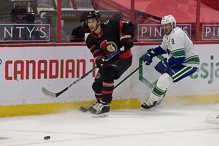 Apr 28, 2021; Ottawa, Ontario, CAN; Ottawa Senators defenseman Artem Zub (2) clears the puck away from Vancouver Canucks center J.T. Miller (9) in the first period at the Canadian Tire Centre. Mandatory Credit: Marc DesRosiers-USA TODAY Sports