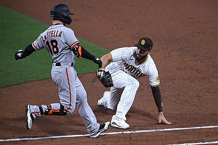 Apr 30, 2021; San Diego, California, USA; San Francisco Giants second baseman Tommy La Stella (18) is tagged out by San Diego Padres first baseman Eric Hosmer (R) after grounding out during the fifth inning at Petco Park. Mandatory Credit: Orlando Ramirez-USA TODAY Sports