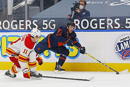 May 1, 2021; Edmonton, Alberta, CAN; Edmonton Oilers forward Connor McDavid (97) tries to make a pass in front on Calgary Flames forward Michael Backlund (11) during the third period at Rogers Place. Mandatory Credit: Perry Nelson-USA TODAY Sports