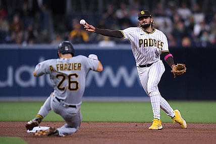 May 3, 2021; San Diego, California, USA; San Diego Padres shortstop Fernando Tatis Jr. (R) throws to first base on a ground out by Pittsburgh Pirates center fielder Bryan Reynolds (not pictured) as second baseman Adam Frazier (26) slides into second base during the fifth inning at Petco Park. Mandatory Credit: Orlando Ramirez-USA TODAY Sports