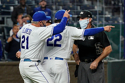 May 5, 2021; Kansas City, Missouri, USA; Kansas City Royals pitching coach Cal Eldred (21) and manager Mike Matheny (22) argue with umpire Angel Hernandez (5) shortly before being ejected in the sixth inning against the Cleveland Indians at Kauffman Stadium. Mandatory Credit: Denny Medley-USA TODAY Sports