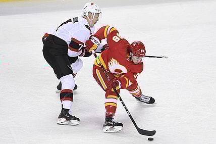 May 9, 2021; Calgary, Alberta, CAN; Calgary Flames forward Andrew Mangiapane (88) battles for the puck with Ottawa Senators forward Brady Tkachuk (7) during the second period at Scotiabank Saddledome. Mandatory Credit: Candice Ward-USA TODAY Sports