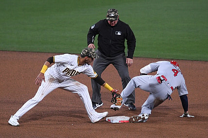May 14, 2021; San Diego, California, USA; St. Louis Cardinals catcher Yadier Molina (4) slides into second base ahead of the tag by San Diego Padres second baseman Tucupita Marcano (L) after hitting a double during the fourth inning as umpire Greg Gibson (C) looks on at Petco Park. Mandatory Credit: Orlando Ramirez-USA TODAY Sports