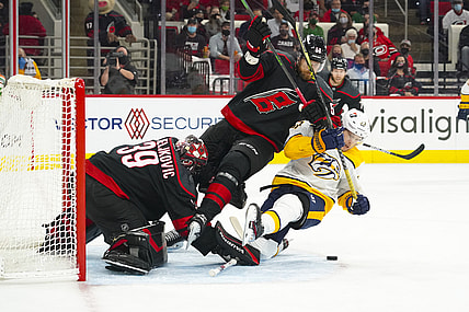 May 17, 2021; Raleigh, North Carolina, USA; Carolina Hurricanes goaltender Alex Nedeljkovic (39) and defenseman Jani Hakanpaa (58) battle Nashville Predators right wing Viktor Arvidsson (33) for the puck during the first period  in game one of the first round of the 2021 Stanley Cup Playoffs at PNC Arena. Mandatory Credit: James Guillory-USA TODAY Sports