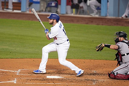 May 20, 2021; Los Angeles, California, USA; Los Angeles Dodgers second baseman Max Muncy (13) follows through on a single during the third inning as Arizona Diamondbacks catcher Stephen Vogt (21) watches  at Dodger Stadium. Mandatory Credit: Kirby Lee-USA TODAY Sports