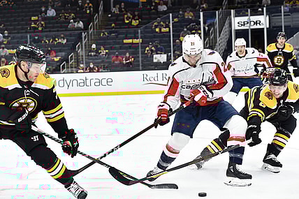 May 21, 2021; Boston, Massachusetts, USA; Boston Bruins left wing Taylor Hall (71) Washington Capitals right wing Garnet Hathaway (21) and defenseman Mike Reilly (6) battle for the puck during the first period in game four of the first round of the 2021 Stanley Cup Playoffs at TD Garden. Mandatory Credit: Bob DeChiara-USA TODAY Sports