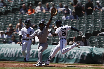 May 30, 2021; Detroit, Michigan, USA; Detroit Tigers center fielder Niko Goodrum (28) safe at first base on a wild throw to New York Yankees first baseman Miguel Andujar (41) during the first inning at Comerica Park. Mandatory Credit: Raj Mehta-USA TODAY Sports