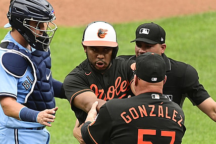 Jun 19, 2021; Baltimore, Maryland, USA;  Baltimore Orioles coach Fredi Gonzalez (57) holds back Baltimore Orioles third baseman Maikel Franco (3) after being hit by a pitch against the Toronto Blue Jays in the fourth inning at Oriole Park at Camden Yards. Mandatory Credit: Tommy Gilligan-USA TODAY Sports