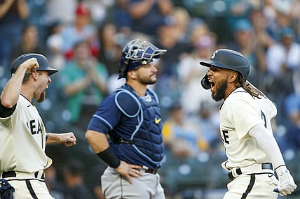 Jun 19, 2021; Seattle, Washington, USA; Seattle Mariners shortstop J.P. Crawford (right) celebrates with catcher Tom Murphy (left) after scoring Murphy with a grand-slam home run against the Tampa Bay Rays during the second inning at T-Mobile Park. Tampa Bay Rays catcher Mike Zunino (10) looks on in the background. Mandatory Credit: Joe Nicholson-USA TODAY Sports