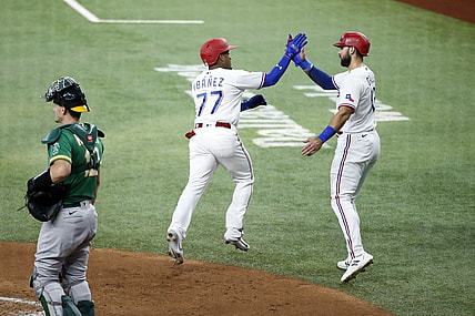 Jun 21, 2021; Arlington, Texas, USA; Texas Rangers second baseman Andy Ibanez (77) is congratulated by right fielder Joey Gallo (13) after hitting a three run home run in the first inning against the Oakland Athletics at Globe Life Field. Mandatory Credit: Tim Heitman-USA TODAY Sports