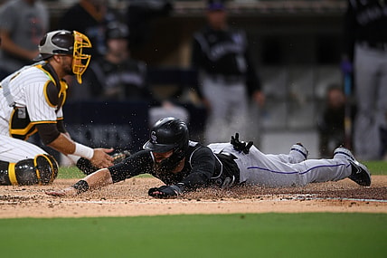 Jul 9, 2021; San Diego, California, USA; Colorado Rockies right fielder Chris Owings (right) slides home to score a run on a double hit by starting pitcher Kyle Freeland (not pictured) during the fourth inning against the San Diego Padres at Petco Park. Mandatory Credit: Orlando Ramirez-USA TODAY Sports