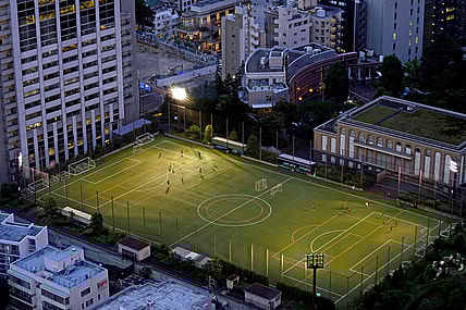 Jul 20, 2021; Tokyo, Japan; People play soccer on a field near the Tokyo Tower before the Tokyo 2020 Summer Olympic Games. Mandatory Credit: Peter Casey-USA TODAY Network