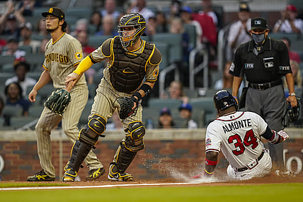 Jul 20, 2021; Cumberland, Georgia, USA; Atlanta Braves left fielder Abraham Almonte (34) scores a run behind San Diego Padres catcher Victor Caratini (17) during the second inning at Truist Park. Mandatory Credit: Dale Zanine-USA TODAY Sports