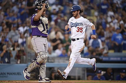 Jul 23, 2021; Los Angeles, California, USA; Los Angeles Dodgers center fielder Cody Bellinger (35) scores as Colorado Rockies catcher Elias Diaz (35) looks on during the first inning at Dodger Stadium. Mandatory Credit: Kelvin Kuo-USA TODAY Sports