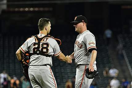 Aug 5, 2021; Phoenix, Arizona, USA; San Francisco Giants relief pitcher Jake McGee (right) celebrates with catcher Buster Posey (28) after defeating the Arizona Diamondbacks at Chase Field. Mandatory Credit: Matt Kartozian-USA TODAY Sports
