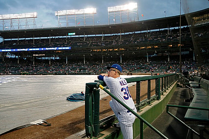 Aug 9, 2021; Chicago, Illinois, USA;  Chicago Cubs starting pitcher Alec Mills (30) leans on the fence in the dugout while looking at the field during a rain delay before the game between the Chicago Cubs and the Milwaukee Brewers at Wrigley Field. Mandatory Credit: Jon Durr-USA TODAY Sports