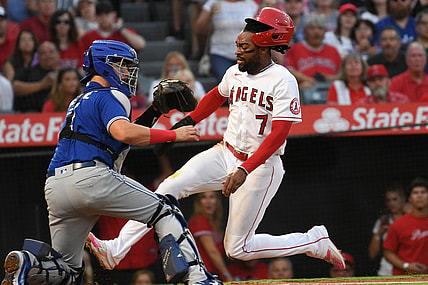 Aug 12, 2021; Anaheim, California, USA;  Los Angeles Angels center fielder Jo Adell (7) scores on a sacrifice fly by catcher Kurt Suzuki (24) (not pictured) past Toronto Blue Jays catcher Reese McGuire (7) in the second inning  at Angel Stadium. Mandatory Credit: Richard Mackson-USA TODAY Sports