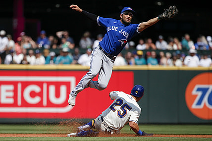 Aug 15, 2021; Seattle, Washington, USA; Toronto Blue Jays second baseman Breyvic Valera (74) catches a throw as Seattle Mariners left fielder Dylan Moore (25) steals second base during the second inning at T-Mobile Park. Mandatory Credit: Joe Nicholson-USA TODAY Sports