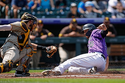 Aug 18, 2021; Denver, Colorado, USA; Colorado Rockies first baseman C.J. Cron (25) slides safely into home against San Diego Padres catcher Austin Nola (26) in the first inning at Coors Field. Mandatory Credit: Isaiah J. Downing-USA TODAY Sports