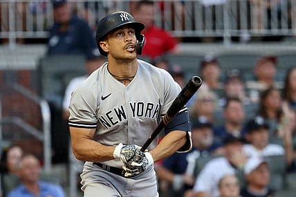 Aug 23, 2021; Atlanta, Georgia, USA; New York Yankees outfielder Giancarlo Stanton (27) hits a solo home run against the Atlanta Braves during the second inning at Truist Park. Mandatory Credit: Jason Getz-USA TODAY Sports