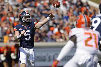 Sep 11, 2021; Charlottesville, Virginia, USA; Virginia Cavaliers quarterback Brennan Armstrong (5) passes the ball as Illinois Fighting Illini defensive back Jartavius Martin (21) watches in the first quarter at Scott Stadium. Mandatory Credit: Geoff Burke-USA TODAY Sports