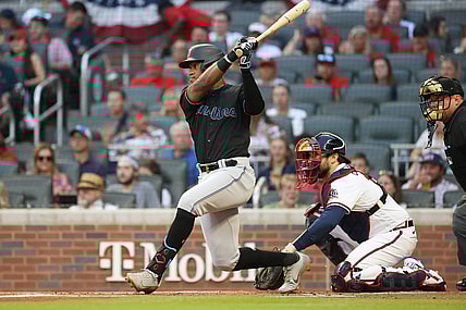 Sep 11, 2021; Atlanta, Georgia, USA; Miami Marlins outfielder Bryan De La Cruz (77) hits an RBI single scoring shortstop Miguel Rojas (not pictured) next to Atlanta Braves catcher Travis d'Arnaud (16) during the first inning at Truist Park. Mandatory Credit: Jason Getz-USA TODAY Sports