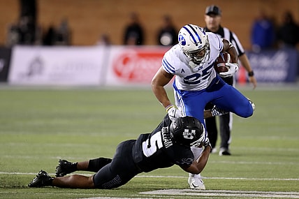 Oct 1, 2021; Logan, Utah, USA; Utah State Aggies linebacker Cash Gilliam (5) tackles Brigham Young Cougars running back Tyler Allgeier (25) during the third quarter at Merlin Olsen Field at Maverik Stadium. Mandatory Credit: Rob Gray-USA TODAY Sports