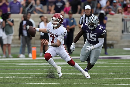 Oct 2, 2021; Manhattan, Kansas, USA; Oklahoma Sooners quarterback Spencer Rattler (7) runs away from Kansas State Wildcats defensive tackle Robert Hentz II (15) during the second quarter of a game at Bill Snyder Family Football Stadium. Mandatory Credit: Scott Sewell-USA TODAY Sports
