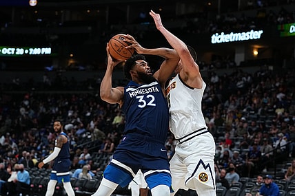 Oct 8, 2021; Denver, Colorado, USA; Minnesota Timberwolves center Karl-Anthony Towns (32) drives at Denver Nuggets center Nikola Jokic (15) in the third quarter at Ball Arena. Mandatory Credit: Ron Chenoy-USA TODAY Sports