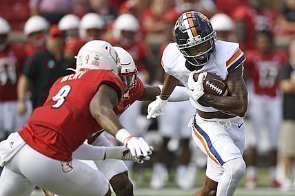 Oct 9, 2021; Louisville, Kentucky, USA;  Virginia Cavaliers wide receiver Dontayvion Wicks (3) runs the ball against Louisville Cardinals linebacker C.J. Avery (9) during the first quarter at Cardinal Stadium. Mandatory Credit: Jamie Rhodes-USA TODAY Sports