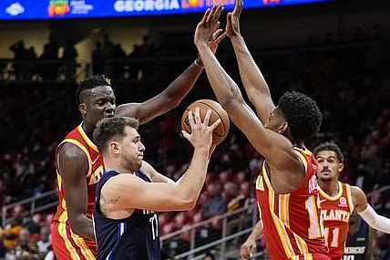 Oct 21, 2021; Atlanta, Georgia, USA; Dallas Mavericks guard Luka Doncic (77) is defended by Atlanta Hawks center Clint Capela (15) and forward De'Andre Hunter (12) during the first half at State Farm Arena. Mandatory Credit: Dale Zanine-USA TODAY Sports