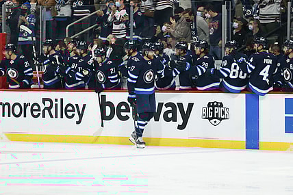 Oct 23, 2021; Winnipeg, Manitoba, CAN;  Winnipeg Jets forward Adam Lowry (17) is congratulated by his team mates on his goal against the Nashville Predators during the first period at Canada Life Centre. Mandatory Credit: Terrence Lee-USA TODAY Sports