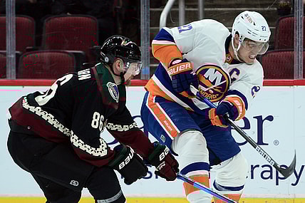 Oct 23, 2021; Glendale, Arizona, USA; New York Islanders center Anders Lee (27) shoots the puck against Arizona Coyotes defenseman Anton Stralman (86) during the first period at Gila River Arena. Mandatory Credit: Joe Camporeale-USA TODAY Sports