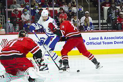Oct 25, 2021; Raleigh, North Carolina, USA; Carolina Hurricanes defenseman Jaccob Slavin (74) defends against Toronto Maple Leafs center Auston Matthews (34) during the first period at PNC Arena. Mandatory Credit: James Guillory-USA TODAY Sports