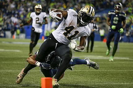 Oct 25, 2021; Seattle, Washington, USA; New Orleans Saints running back Alvin Kamara (41) breaks a tackle by Seattle Seahawks defensive back Ryan Neal (26) to score a touchdown on a reception during the second quarter at Lumen Field. Mandatory Credit: Joe Nicholson-USA TODAY Sports