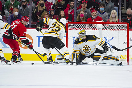 Oct 28, 2021; Raleigh, North Carolina, USA; Boston Bruins goaltender Jeremy Swayman (1) and defenseman Charlie McAvoy (73) stop the scoring attempt by Carolina Hurricanes defenseman Tony DeAngelo (77) during the first period at PNC Arena. Mandatory Credit: James Guillory-USA TODAY Sports