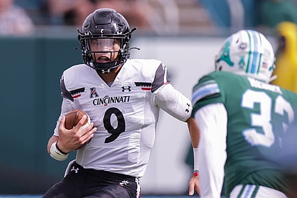 Oct 30, 2021; New Orleans, Louisiana, USA;  Cincinnati Bearcats quarterback Desmond Ridder (9) runs against Tulane Green Wave linebacker Kevin Henry (33) during the first half at Yulman Stadium. Mandatory Credit: Stephen Lew-USA TODAY Sports