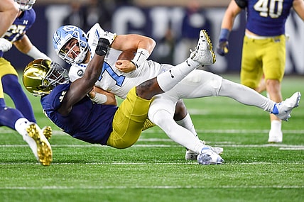 Oct 30, 2021; South Bend, Indiana, USA; North Carolina Tar Heels quarterback Sam Howell (7) is tackled by Notre Dame Fighting Irish defensive lineman Nana Osafo-Mensah (31) in the first quarter at Notre Dame Stadium. Mandatory Credit: Matt Cashore-USA TODAY Sports