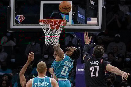 Oct 31, 2021; Charlotte, North Carolina, USA; Charlotte Hornets forward Miles Bridges (0) makes a reverse layup past Portland Trail Blazers center Jusuf Nurkic (27) during the second quarter at Spectrum Center. Mandatory Credit: Jim Dedmon-USA TODAY Sports