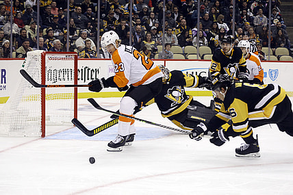 Nov 4, 2021; Pittsburgh, Pennsylvania, USA; Philadelphia Flyers left wing Oskar Lindblom (23) and Pittsburgh Penguins defenseman John Marino (6) chase the puck in front of Penguins goaltender Tristan Jarry (35) during the first period at PPG Paints Arena. Mandatory Credit: Charles LeClaire-USA TODAY Sports
