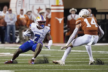 Nov 13, 2021; Austin, Texas, USA; Kansas Jayhawks running back Keilan Robinson (7) tries to avoid a tackle by Texas Longhorns defensive back Brenden Schooler (14) during the first half at Darrell K Royal-Texas Memorial Stadium. Mandatory Credit: Scott Wachter-USA TODAY Sports