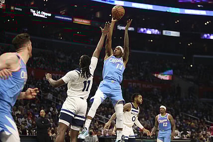 Nov 13, 2021; Los Angeles, California, USA; Los Angeles Clippers guard Terance Mann (14) shoots the ball over Minnesota Timberwolves center Naz Reid (11) during the second quarter at Staples Center. Mandatory Credit: Kiyoshi Mio-USA TODAY Sports