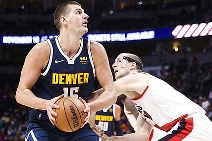 Nov 14, 2021; Denver, Colorado, USA; Denver Nuggets center Nikola Jokic (15) goes up for a shot over Portland Trail Blazers center Cody Zeller (40) in the first quarter at Ball Arena. Mandatory Credit: Michael Ciaglo-USA TODAY Sports